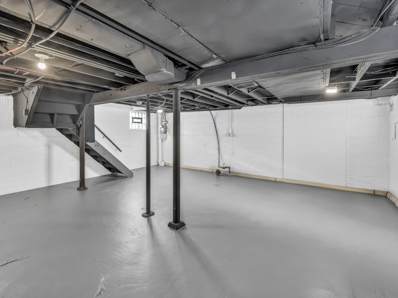 Unfinished basement with concrete walls and exposed structure